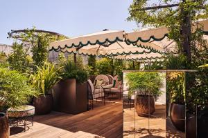 a patio with chairs and potted plants and an umbrella at Hôtel Fouquet's Paris in Paris +84 photos