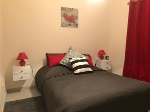 1 dormitorio con 1 cama con 2 mesitas de noche y 2 lámparas en Ikaria Village , apartment 202 en Pafos