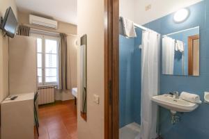 een blauwe badkamer met een wastafel en een spiegel bij Hotel Genesi in Florence +28 foto's