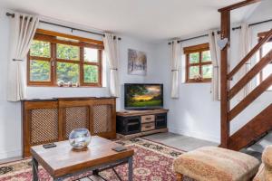 a living room with a television and a table at The Pigsty - 3 Bedroom Barn Conversion in Coventry