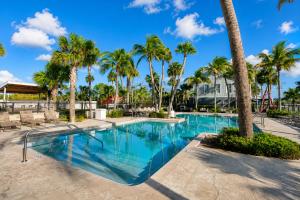 a pool with palm trees and a roller coaster at Elegant Sailboat Stay in Key West