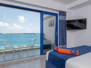 a bedroom with a view of the ocean at Kaani Palm Beach in Maafushi