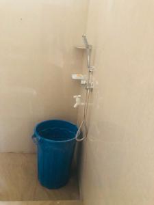 a blue bucket in a bathroom with a shower at Sanku guest house in Jaffna