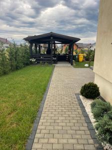 a gazebo with a bench in a yard at Cazare Băile Figa -The Home DRM in Beclean