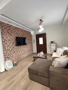 a living room with a brick wall and a couch at Evita's House in Doxato