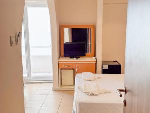 a room with a bed and a tv and a window at Er-öz Hotel & Restaurant in Fethiye