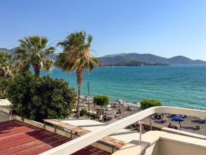 a view of a beach with palm trees and the ocean at Er-öz Hotel & Restaurant in Fethiye