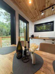 a bottle of wine and a flower on a table at Wild Crib Avrig in Avrig +10 photos