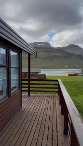 a wooden deck next to a house with mountains in the background at Olga Apartments in Grundarfjordur