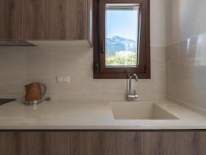 a kitchen counter with a sink and a window at Elaionas Houses in Skala Potamias +47 photos
