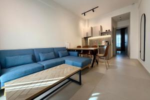 a living room with a blue couch and a table at GLEN Premium Stays in Kanali