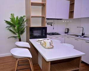 a kitchen with white cabinets and a table and chairs at TM Homes in Abuja +12 photos