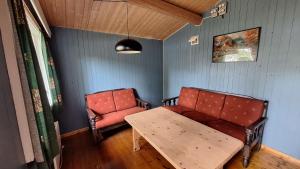 a living room with a table and a chair at Fossen Camping Fagernes in Døvre