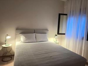 a bedroom with a large bed with two tables and two lamps at aganta apartments in Olympiada