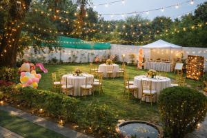 a wedding reception in a marquee with tables and chairs and lights at Ardor Homestay in Jabalpur