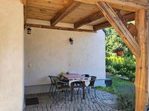 a patio with a table and chairs under a wooden ceiling at Ferienwohnungen Familie Gottfried in Schirgiswalde