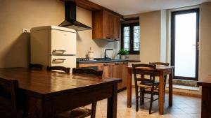 a kitchen with a wooden table and a refrigerator at la Pace camere con bagno nel centro storico di Stia in Stia