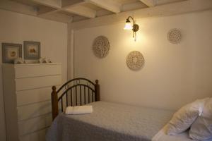 a bedroom with a bed and a lamp on the wall at Skalopetra in Pylos