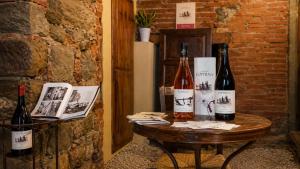 two bottles of wine sitting on a table at la Pace camere con bagno nel centro storico di Stia in Stia +18 photos