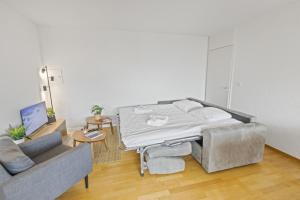 a bed in a living room with a couch at Appartement central et confortable in Crans-Montana