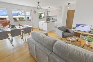 a living room with a couch and a table and a kitchen at Appartement central et confortable in Crans-Montana