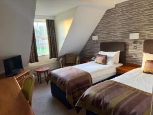 a hotel room with two beds and a tv at The Bridge Hotel and Spa in Wetherby