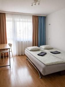 a bedroom with a bed and a table and a desk at Rooms Gdynia Orłowo in Gdynia