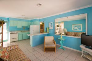 a living room with blue walls and a kitchen at Captiva Island Inn in Captiva