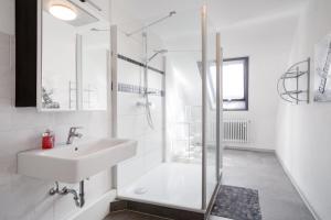 a white bathroom with a sink and a shower at Hotel Romäus in Villingen-Schwenningen +47 photos