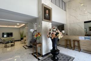 a lobby with a vase of flowers in the lobby at Baan Thanakul Suvarnabhumi in Ban Khlong Nong Pru