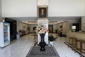 a lobby with a vase of flowers on a tile floor at Baan Thanakul Suvarnabhumi in Ban Khlong Nong Pru