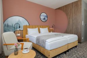a bedroom with a large bed and a chair at Santa Christina Mountain Resort in Świeradów-Zdrój +22 photos
