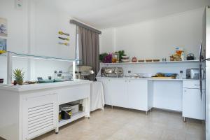a kitchen with white counters and white cabinets at Beach Break Rhodes in Faliraki