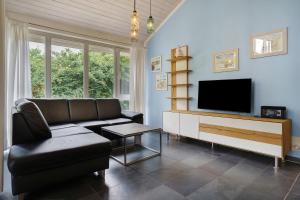 a living room with a couch and a television at Haus E 1 in Röbel