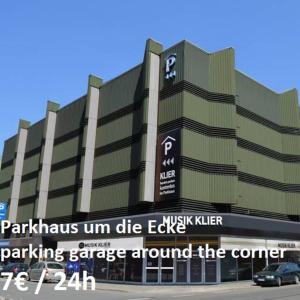 a large building with a parking garage around the corner at P63 City Rooms Nürnberg Center in Nuremberg