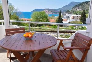 a wooden table with a bowl of fruit on a balcony at Apartman Lavanda in Sutomore