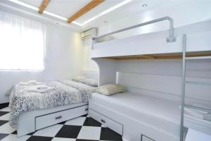 a bedroom with a bunk bed and a checkered floor at Apartman Lavanda in Sutomore