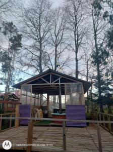 a gazebo with purple chairs on a wooden deck at Departamento con tinaja in Llanquihue