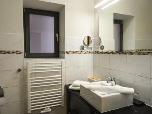 a white bathroom with a sink and a mirror at Fründts Hotel in Wismar +30 photos