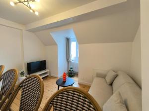 a living room with a couch and a tv at Hyper Centre Beauvais Cosy Appartement in Beauvais