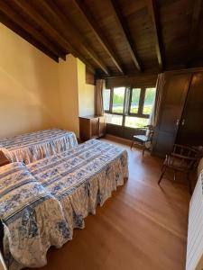 a bedroom with two beds in a room at Gestiona2R - Casa Dos Carmenes, caminando a la playa, ideal familias in Llanes