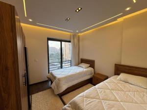 a bedroom with two beds and a window at Rent house b8 in Madinaty