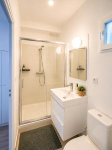 a white bathroom with a shower and a sink at Superbe studio proche Disney in Champs-sur-Marne