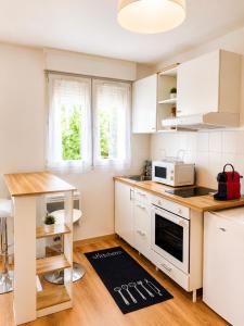 a kitchen with white cabinets and a kitchen rug on the floor at Superbe studio proche Disney in Champs-sur-Marne