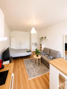 a living room with a couch and a bed at Superbe studio proche Disney in Champs-sur-Marne