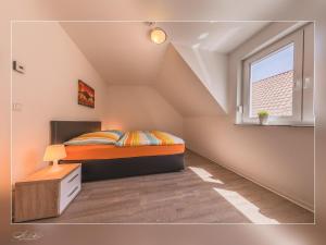 a attic bedroom with a bed and a window at Fewo Müritzfrische 2 in Waren