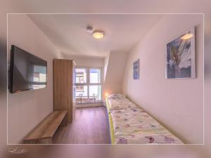 a room with a bed and a flat screen tv at Fewo Müritzfrische 2 in Waren