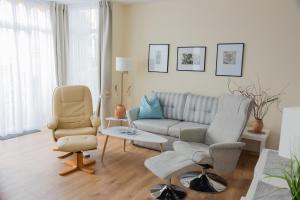a living room with a couch and two chairs at Am Seeufer 59 Fewo 1 in Waren