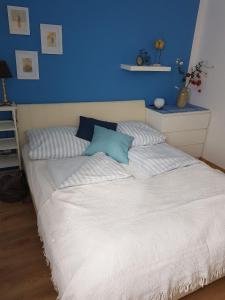 a bedroom with a bed with a blue wall at Am Seeufer 59 Fewo 1 in Waren