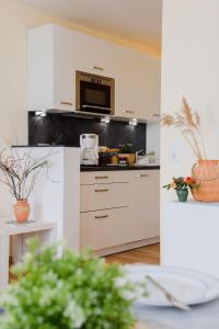 a kitchen with white cabinets and a microwave at Am Seeufer 59 Fewo 1 in Waren